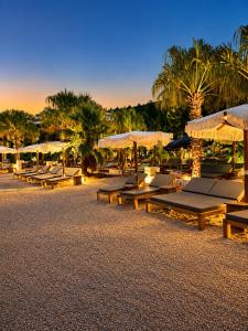 a group of picnic tables and umbrellas on a beach at Villa Bonaca in Korčula