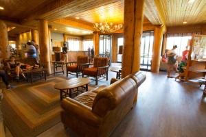 a living room with a couch and tables and people at Headwaters Lodge & Cabins at Flagg Ranch in Moran