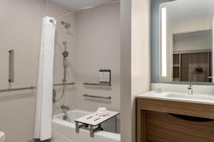 a bathroom with a sink and a tub and a mirror at Hyatt Studios Chesapeake in Chesapeake +45 photos