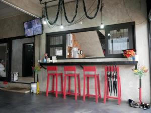 a bar with red stools in front of a mirror at 41Studio in Nakhon Phanom