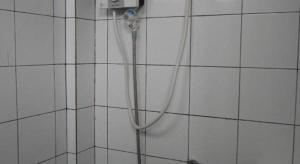 a shower with a hose attached to a white tiled wall at 41Studio in Nakhon Phanom +41 photos