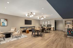 a living room with tables and chairs and a couch at Hyatt Studios Chesapeake in Chesapeake