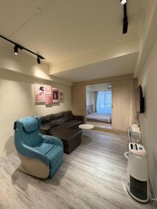 a living room with a blue chair and a couch at 樂室Room in Nanwan