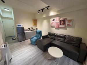 a living room with a couch and a table and a kitchen at 樂室Room in Nanwan