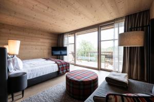 a bedroom with a bed and a large window at ADLER Ritten in Soprabolzano +37 photos