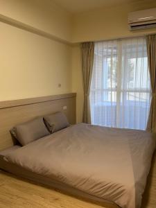 a bedroom with a large bed with a window at 樂室Room in Nanwan