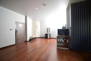a living room with a television and a wooden floor at CHANTHABURI CENTER in Chanthaburi