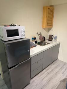a kitchen with a microwave on top of a refrigerator at 樂室Room in Nanwan +4 photos