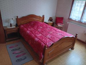a bedroom with a large bed with a red comforter at Auberge leon xiv in Sarralbe