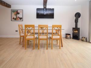 a dining room with a table and chairs and a fireplace at Hay Barn in Carnforth
