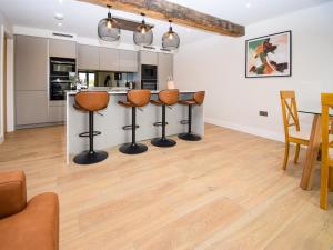 a kitchen and living room with a counter and chairs at Hay Barn in Carnforth