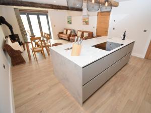 a kitchen with a white counter top and a living room at Hay Barn in Carnforth +23 photos