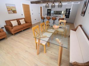 a living room with a glass table and chairs at Hay Barn in Carnforth