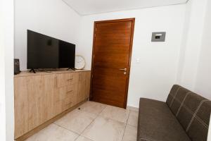 a living room with a tv and a wooden door at Loft Reforma in Oaxaca City