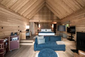 a bedroom with a bed and a blue couch in a room at ADLER Ritten in Soprabolzano
