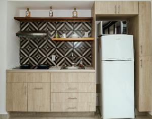 a kitchen with a refrigerator and a sink at Loft Reforma in Oaxaca City +2 photos