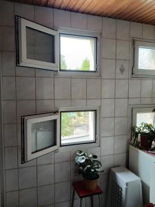 a tiled wall with three windows in a room at Auberge leon xiv in Sarralbe