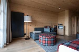 a living room with a blue couch and a lamp at ADLER Ritten in Soprabolzano