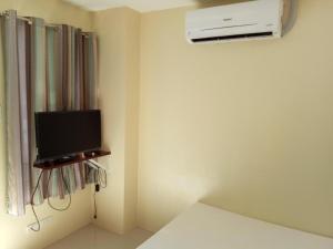a room with a tv and a air conditioner at Dino Residences in Daro
