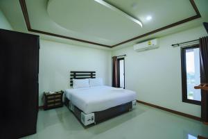 a bedroom with a white bed and a window at AmornSukhothai Hotel in Sukhothai