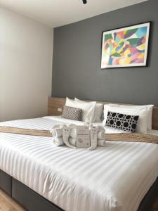 a bedroom with a large bed with white sheets and pillows at โรงแรม เดอะโมเดล การ์เด้น in Yasothon