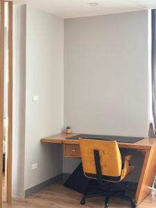 an office with a wooden desk with a yellow chair at โรงแรม เดอะโมเดล การ์เด้น in Yasothon
