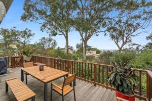 a wooden deck with a table and chairs on it at Gunyha - Ocean Views, Walk to Beach, Free WiFi, Pet Friendly, Open Fire, Visiting Koalas and Other Wildlife. in Apollo Bay