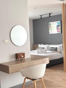 a bedroom with a bed and a mirror and a chair at โรงแรม เดอะโมเดล การ์เด้น in Yasothon +37 photos