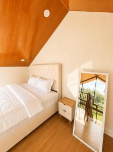 a bedroom with a bed and a mirror at Villa With Jacuzzi, Damar Ningrum 3 in Tutugan