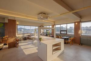 a large room with tables and chairs and windows at Wolyoung Hotel By NewCZ in Andong