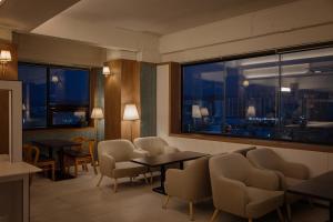 a waiting room with tables and chairs and windows at Wolyoung Hotel By NewCZ in Andong