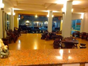 a lobby with tables and chairs in a building at Chanthanee Hotel in Ban Chamun (2)