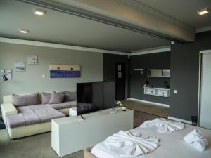 a living room with a couch and a tv at La Vella Resort in Dubova
