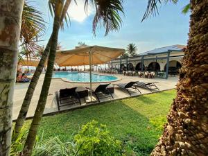 a swimming pool with chairs and a large umbrella at Lago de Oro in Balibago