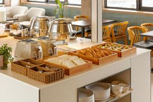 a breakfast buffet with bread and pastries on a counter at Wolyoung Hotel By NewCZ in Andong +94 photos