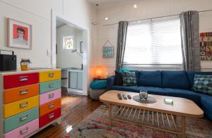 a living room with a blue couch and a table at Blackheath Nook in Blackheath