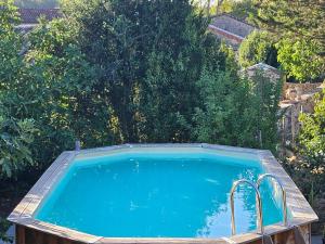 a large swimming pool in a yard with trees at Chambre d'hôtes Le Luquet in Chazelles