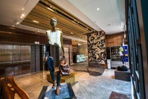 a statue of a man sitting on a bench in a lobby at Ehotel in Hong Kong