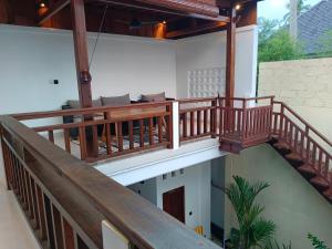 a balcony with wooden railings on a house at Artha Sadia Villa 1 Seseh Beach in Cemagi