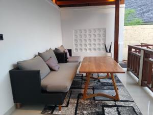 a living room with a couch and a wooden table at Artha Sadia Villa 1 Seseh Beach in Cemagi
