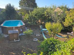 a pool in a yard with a bench and a table at Roulotte bohème in Chazelles