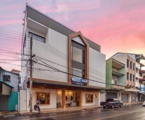 a building on a street with a truck parked in front at Need a Nap Hostel Phrae in Phrae