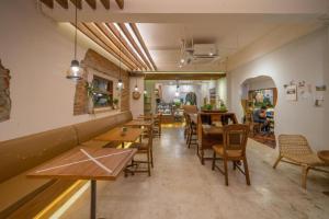 a restaurant with tables and chairs in a room at Need a Nap Hostel Phrae in Phrae