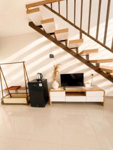 a living room with a staircase and a tv at Villa With Jacuzzi, Damar Ningrum 3 in Tutugan