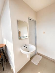 a white bathroom with a sink and a mirror at Villa With Jacuzzi, Damar Ningrum 3 in Tutugan +14 photos