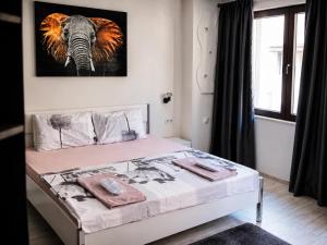 a bedroom with a bed with a picture of an elephant at Medius Park Apartment in Sandanski