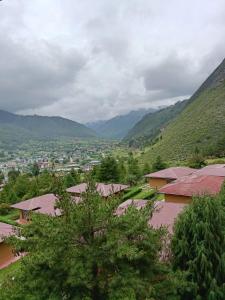 a view of a village with mountains in the background at Drukyul Kora Tours & Treks in Thimphu