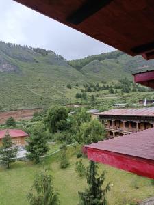 a red building with a view of a mountain at Drukyul Kora Tours & Treks in Thimphu