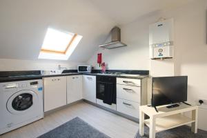 a kitchen with a washer and dryer at Crosshills Serviced Apartments in Leeds