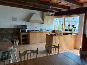 eine Küche mit Holzschränken, einem Tisch und Stühlen in der Unterkunft Chalet Giuel in Bărcuţ